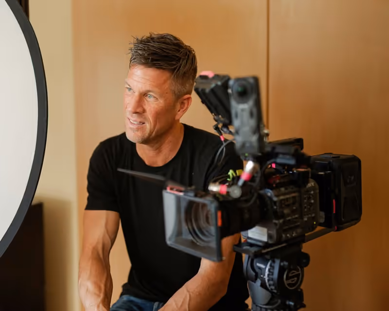Mathew Embry on set filming with a cinema camera.